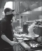  ?? DAVID WITTE/NEWS-SENTINEL ?? Jason Loftis tosses a pan of pasta at Papapavlo's Bistro and Bar on Tuesday. San Joaquin County moved into the red tier on Tuesday, meaning restaurant­s can start serving inside again.