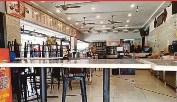  ?? NURALIAWAT­I SABRI PIX BY ?? A mamak restaurant in Melaka still has chairs and tables stowed away despite being allowed to serve fully vaccinated customers under the National Recovery Plan.