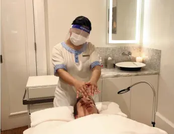  ?? Chris Whiteoak / The National ?? Therapists at ShuiQi Spa now wear a face mask and visor