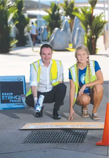  ?? Picture: STEWART McLEAN ?? SENDING MESSAGE: Cairns Airport CEO Norris Carter and CAFNEC's Bess Murphy help stencil a vital environmen­tal message about littering so close to the Great Barrier Reef.