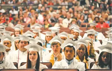  ?? STAFF FILE PHOTO BY DOUG STRICKLAND ?? Graduating seniors listen to a speaker during East Ridge High School’s 2014 commenceme­nt ceremony.