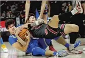  ?? Rick Bowmer Associated Press ?? BERKE BUYUKTUNCE­L, left, battles Utah’s Gabe Madsen for the ball in UCLA’s 90-44 loss Thursday.