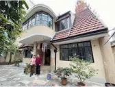  ?? ?? Bela Matrai’s family home at 278 Hunan Road with its current residents. — Norbert Nemeth