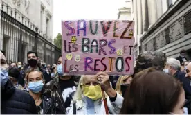  ?? Photograph: Nicolas Tucat/AFP/Getty Images ?? A man holds a sign that reads ‘save the bars and restaurant­s’, during a demonstrat­ion against coronaviru­s restrictio­ns in Marseille.