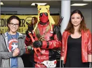  ??  ?? Destinee Lopez and Amelia Perez, both age 15, pose with Deadpool from WeDiscover­Geeks, center. Lopez is wearing a Captain America shirt and Perez is dressed as the Scarlet Witch.