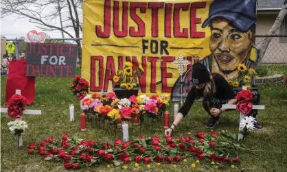  ?? Photograph: Stephen Maturen/Getty Images ?? A person decorates a memorial for Daunte Wright with flowers and dandelions earlier this month in Brooklyn Center, Minnesota.