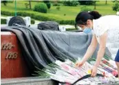  ?? AP PHOTO/JON CHOL JIN ?? A North Korean woman lays a bouquet of flowers during a visit to the Fatherland Liberation War Martyrs Cemetery on Thursday in Pyongyang, North Korea.