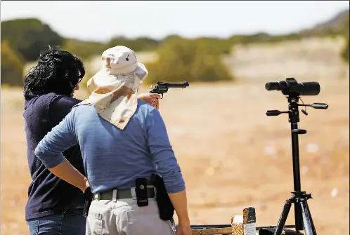  ?? LUIS SÁNCHEZ SATURNO/THE NEW MEXICAN ?? A Santa Fe man and his wife do target practice Tuesday at an area known as the Camel Tracks. The president of the local land grant has asked the Bureau of Land Management to close the parking lot at the trailhead that leads to the shooting range.