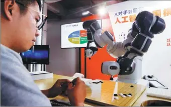  ?? TANG YANJUN / CHINA NEWS SERVICE ?? A visitor to the 2018 World Artificial Intelligen­ce Conference, which opened on Monday in Shanghai, plays Go with a robot.