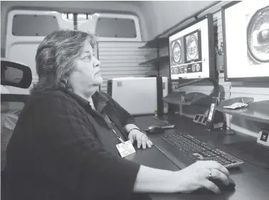  ?? STAFF PHOTOS BY C.B. SCHMELTER ?? Above: Bureau of Alcohol, Tobacco, Firearms and Explosives NIBIN Specialist Erin Hine demonstrat­es the technologi­es inside the NIBIN van Wednesday.