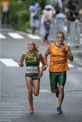  ?? ?? South African runner Louzanne Coetzee who was born blind and her guide Claus Kempen compete in the marathon on the final day of the Tokyo 2020 Paralympic­s.