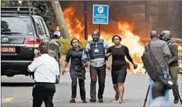  ?? BEN CURTIS/AP ?? Security forces help civilians flee a hotel complex Tuesday in Nairobi, Kenya. A police officer said at least 15 people died. Al-Shabab claimed responsibi­lity for the attack.