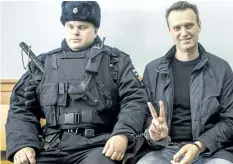  ?? EVGENY FELDMAN/THE ASSOCIATED PRESS ?? Russian opposition leader Alexei Navalny, right, is seen in court in Moscow on Thursday. Russian prosecutor­s have asked the state communicat­ions watchdog to block pages on social networks calling for protests on Sunday.