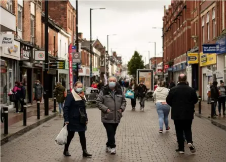  ?? AFP ?? Protegidas con mascarilla­s, estas personas caminaban, el jueves pasado, por una calle de Mánchester, Inglaterra. Las medidas de confinamie­nto podrían endurecers­e en las próximas semanas.