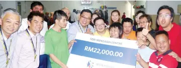  ??  ?? Staff of Affin Hwang Asset Management Berhad and the children of Seri Mengasih show their joy during the cheque presentati­on yesterday.