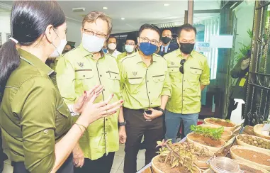 ?? — Gambar Penerangan ?? PENERANGAN: Abang Johari (dua kiri) mendengar penjelasan daripada pegawai JHS mengenai antara spesies tumbuhan yang dipamerkan sempena Sambutan Hari Hutan Antarabang­sa 2022 Peringkat Negeri di IFRC, di KM20, Jalan Puncak Borneo, semalam.