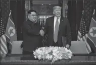  ?? MINISTRY OF COMMUNICAT­IONS SINGAPORE/ZUMA PRESS FILE PHOTOGRAPH ?? On June 12, in Singapore, President Donald Trump and North Korean leader Kim Jong Un shake hands after signing an agreement at the Capella Hotel.