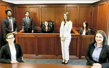  ??  ?? Elizabeth DeLosa, in white, managing attorney for the Pennsylvan­ia Innocence Project's Pittsburgh office, stands along with, from left, law students Jennifer Vogel, seated, from Duquesne University; Sean Champagne, University of Pittsburgh; Kyle...