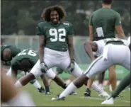  ?? JULIO CORTEZ — ASSOCIATED PRESS ?? Jets nose tackle Leonard Williams, center, laughs while talking to a staff member during practice at the team's training facility in Florham Park, N.J., on Friday.