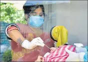  ?? SAMEER SEHGAL/HT ?? A health worker collecting a woman’s nasal swabs for Covid-19 at the Amritsar civil hospital on Monday,