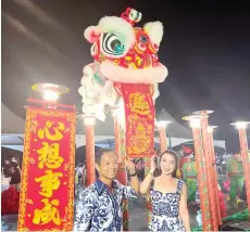  ?? ?? Francis and his wife receiving a souvenir from the lion dance group during the Chinese New Year dinner.