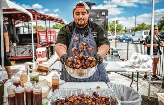  ?? Robert J. Lerma ?? Luis Lopez, of Killen’s Barbecue, makes pork-belly bites at the 2017 Houston Barbecue Festival.