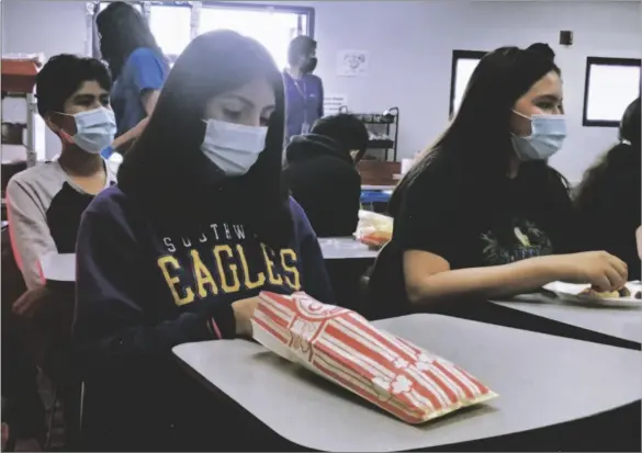  ?? PHOTO CELESTE GARIBAY ?? FROM LEFT: Andri Calihua,14, Nirvana Diaz, 14, and Anahi Gonzalez, 15, eat food that was provided at the Arc Program’s movie night event at Southwest High School on Oct. 22.