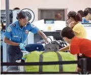  ?? Alan Diaz / Associated Press ?? A TSA agent gets items ready for screening over the weekend at the Fort Lauderdale-Hollywood airport.