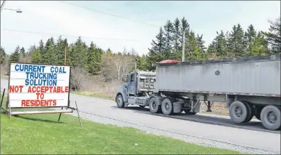  ?? SHARON MONTGOMERY-DUPE/CAPE BRETON POST ?? A coal truck heading to the Donkin Mine travels down the Long Beach Road in Port Morien, past a protest sign Claude Peach has set up on his front lawn. Port Morien residents are concerned over the heavier traffic and the safety of the children.