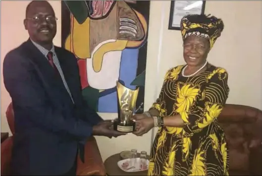  ??  ?? National Arts Council of Zimbabwe director Nicholas Moyo hands over the National Arts and Merits Awards (Nama) Lifetime Achievemen­t Award to mbira musician Mbuya Stella Chiweshe in Harare on Friday. The legend was not in the country in March when Nama rewarded 39 other arts legends. mbira