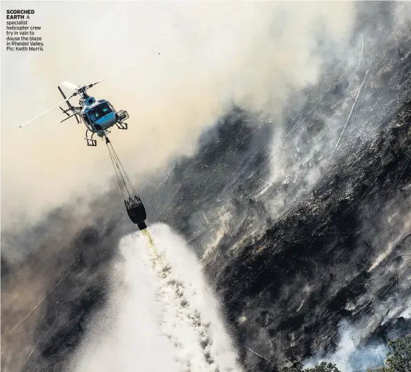  ??  ?? SCORCHED EARTH A specialist helicopter crew try in vain to douse the blaze in Rheidol Valley. Pic: Keith Morris