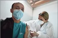  ?? Getty Images ?? A healthcare worker administer­s a Chinese-made Sinopharm Covid-19 vaccine in Belgrade, Serbia, on Monday.