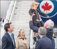  ?? CP PHOTO RYAN REMIORZ ?? Canadian Ambassador to Ireland Kevin Vickers tosses Hadrien Trudeau into the air as Prime Minister Justin Trudeau and his wife, Sophie Gregoire Trudeau, look on after arriving in Dublin, Ireland, Monday, July 3.