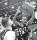  ?? CHARLES KRUPA/AP ?? Mount St. Mary’s guard Damian Chong
Qui hoists the trophy as he celebrates with teammates after their win in the NEC title game in Smithfield, R.I.