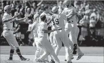  ?? Jason O. Watson Getty Images ?? AN ECSTATIC Jonathan Lucroy, right, is mobbed by his Athletics teammates after hitting a game-winning single in the 11th inning Sunday. The Angels have 15 blown saves, tied for the most in the majors with Detroit.