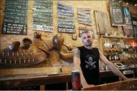  ?? JOHN MINCHILLO — THE ASSOCIATED PRESS ?? Shane Juhl, owner and proprietor of Toxic Brew Co., poses for a photograph at his taproom located in the Oregon District, Tuesday, July 17, 2018, in Dayton, Ohio. After experienci­ng its best days in the first half of the 20th century, Dayton is reinventin­g itself with impressive results. Minor-league baseball, a riverside park and a cluster of craft beer pubs are helping revitalize a downtown that had become frayed around the edges.