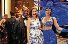  ?? Annie Mulligan photos ?? Astley and Alex Blair, from left, pose with one of the showgirls at the Las Vegastheme­d Houston Symphony Ball.