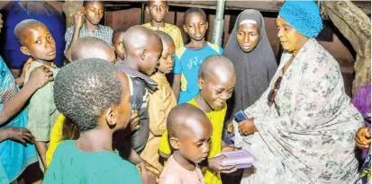  ?? PHOTO: NAN ?? President, African Mothers Humanitari­an for Peace and Justice for Mother and Children (AMHPJMC) Dr Amina Dangaji (R) distributi­ng cooked food to the less privilege at Kawo New Extension in Kaduna on Monday.