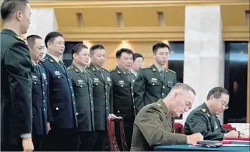  ?? Andrew Harnik Associated Press ?? JOINT CHIEFS Chairman Gen. Joseph F. Dunford Jr., second from right, and his Chinese counterpar­t, Gen. Fang Fenghui, sign an agreement in Beijing to strengthen communicat­ion between their nations’ militaries.