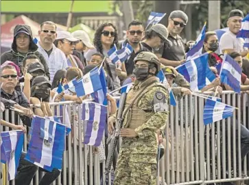  ?? Camilo Freedman SOPA Images/LightRocke­t ?? A SOLDIER monitors a military parade Sept. 15 in San Salvador, El Salvador. Opponents of President Nayib Bukele call his 2024 reelection effort unconstitu­tional and say it would help him tighten his authoritar­ian grip.