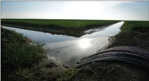  ?? AP PHOTO BY RICH PEDRONCELL­I ?? In this Feb. 25, 2016 photo, water flows through an irrigation canal to crops near Lemoore. Farmers in the nation’s largest irrigation district are considerin­g whether to sign on to California’s biggest water project in a half-century