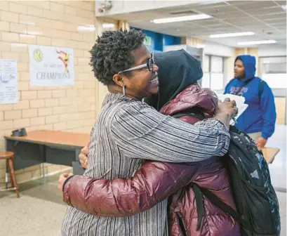  ?? JERRY JACKSON/BALTIMORE SUN ?? Principal Tricia Lawrence hugs a student in the hallway of Mergenthal­er Vocational-Technical High School toward the end of a February school day.