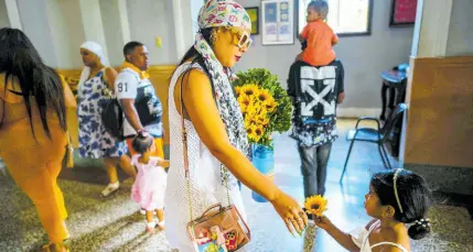  ?? AP ?? A mother and daughter prepare to make an offering of sunflowers to the Virgin of Charity of Cobre at her shrine in El Cobre, Cuba. The Vaticanrec­ognised Virgin, venerated by Catholics and followers of AfroCuban Santeria traditions, is at the heart of Cuban identity, uniting compatriot­s from the Caribbean island to those who were exiled or emigrated to the US.