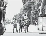  ?? PATRICK SEMANSKY/AP ?? Grant Curry, left, of Indianapol­is, and his son Gavin take part in a rally May 13 to raise awareness of bus operators.