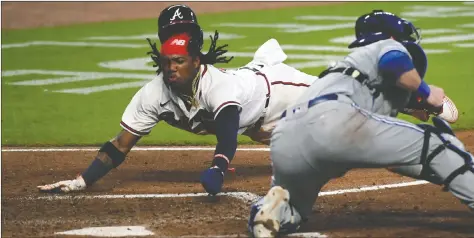  ?? USA TODAY SPORTS ?? Atlanta Braves star Ronald Acuna Jr. dives into home safely against Toronto Blue Jays catcher Danny Jansen during Tuesday night’s 10-1 Braves victory in Atlanta.