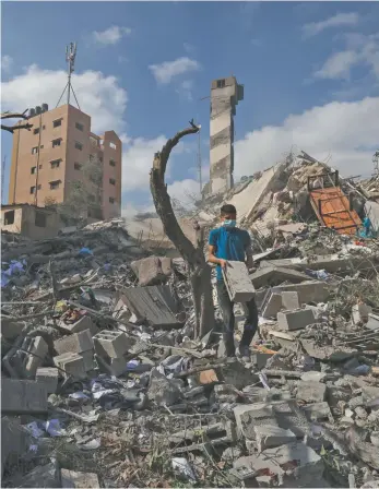  ?? Mahmud Hams / AFP ?? A Palestinia­n youth in the rubble of the Kuhail building in Gaza City this week.