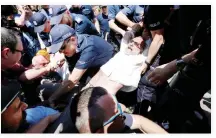  ??  ?? Police officers struggle with anti-government protesters in Warsaw, Poland, on Monday. (Reuters)