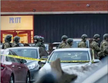  ?? MATT MARTON — THE ASSOCIATED PRESS ?? Law enforcemen­t officers gather outside the Henry Pratt Co. manufactur­ing plant Friday in Aurora, Ill. Police say a gunman killed several people and injured police officers before he was fatally shot.