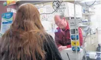  ?? LLOYD FOX/BALTIMORE SUN ?? Charlie Ward serves a customer at his Brooklyn Park check cashing business. “We’re better than the banks,” he said. “For a lot of people we’re just a lot more reasonably priced — and Lord knows we try to be a lot friendlier than any of the banks.”