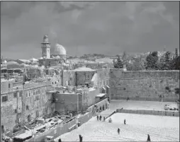  ?? AP/DUSAN VRANIC ?? A dusting of snow
covers the area around Jerusalem’s Western Wall (right) and the Dome of the Rock (left) in the area known to Jews as the Temple Mount and to Muslims as Haram al-Sharif, or the Noble Sanctuary.